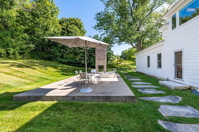 view of yard with a patio and exterior fireplace