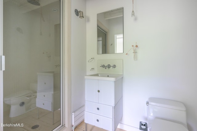 bathroom featuring tile patterned floors, toilet, a shower with door, and sink