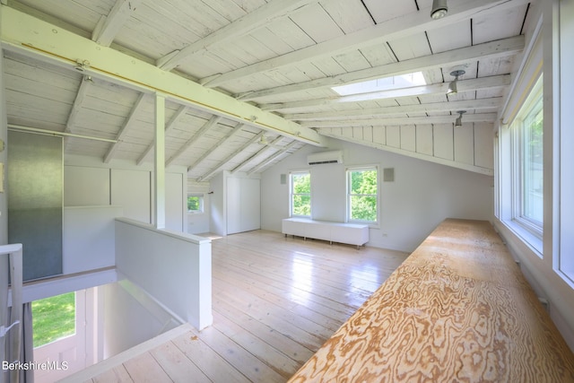 additional living space with light wood-type flooring, an AC wall unit, wooden ceiling, and vaulted ceiling with skylight