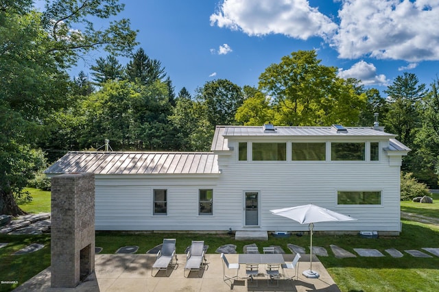 back of house with a patio area and a yard