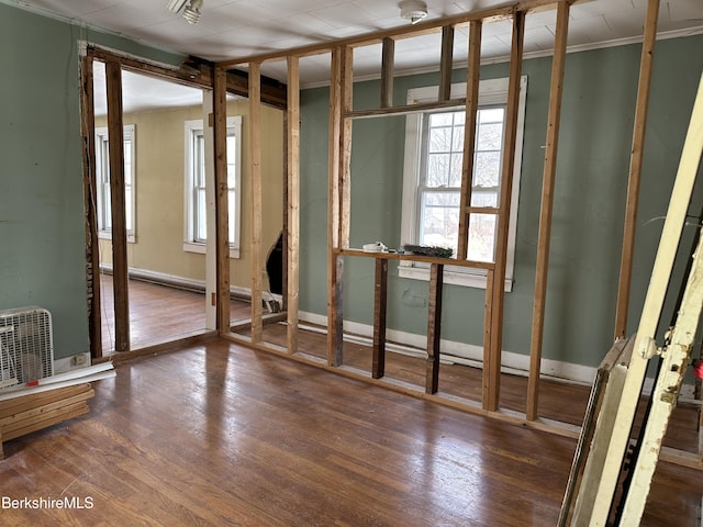 misc room with dark wood-type flooring, a wealth of natural light, and ornamental molding