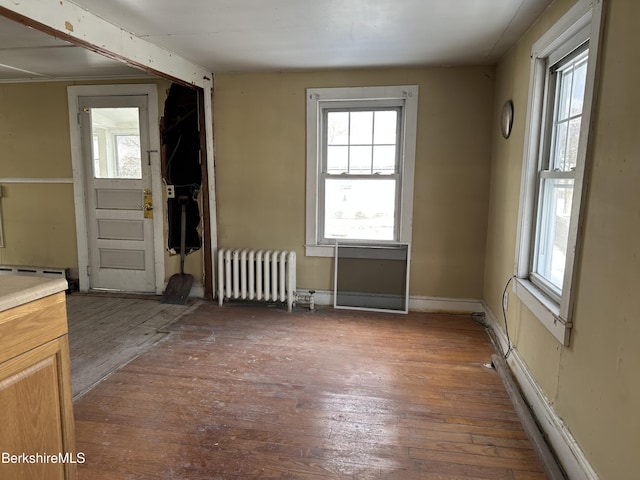 interior space with dark wood-type flooring and radiator heating unit