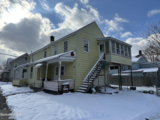 view of snow covered rear of property