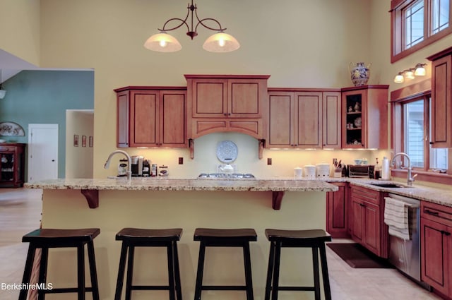 7 Perry Rd, Sandisfield, MA 01255 - kitchen with a high ceiling, stainless steel dishwasher, light stone counters, a breakfast bar area, and pendant lighting