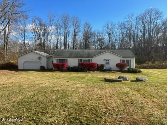 ranch-style home with a garage and a front lawn