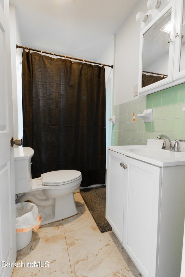 bathroom featuring toilet, vanity, and marble finish floor