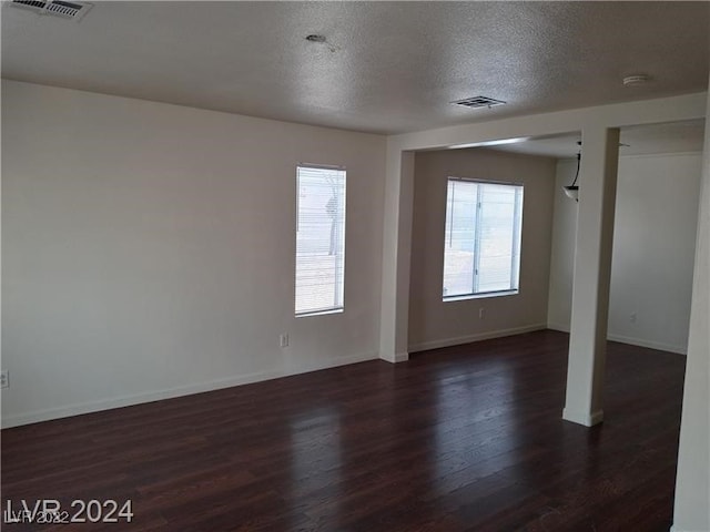 unfurnished room featuring a textured ceiling and dark wood-type flooring