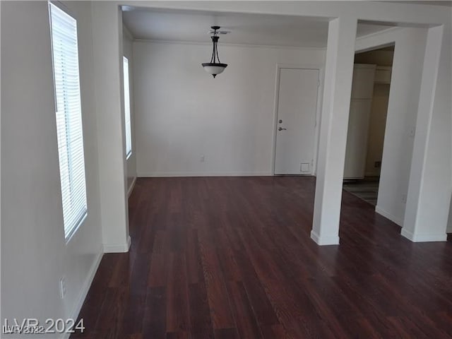 unfurnished room featuring a wealth of natural light and dark hardwood / wood-style flooring