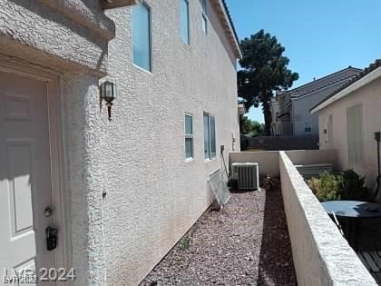 view of side of home featuring a balcony and central air condition unit