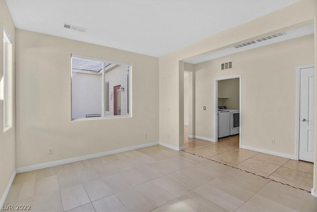 empty room featuring separate washer and dryer and light tile floors