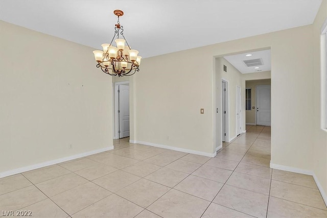 empty room with a chandelier and light tile floors