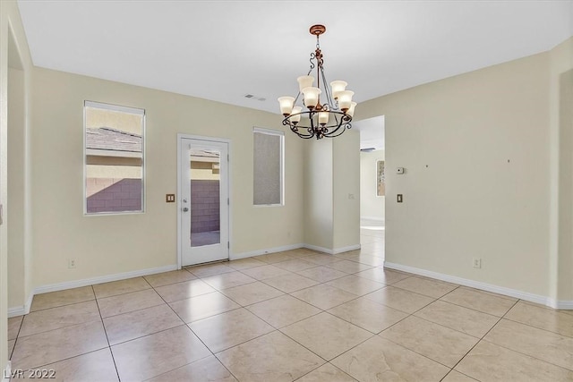 unfurnished room with a notable chandelier and light tile flooring