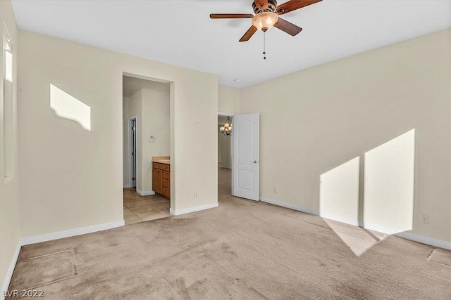 interior space featuring light carpet and ceiling fan with notable chandelier