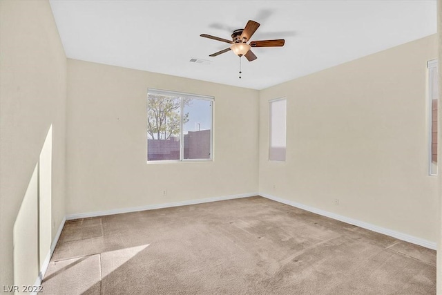 empty room with ceiling fan and light colored carpet