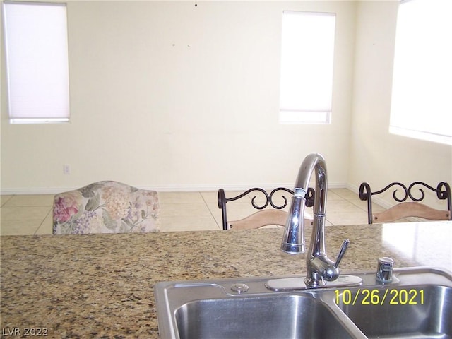 kitchen featuring sink, light stone counters, and light tile floors