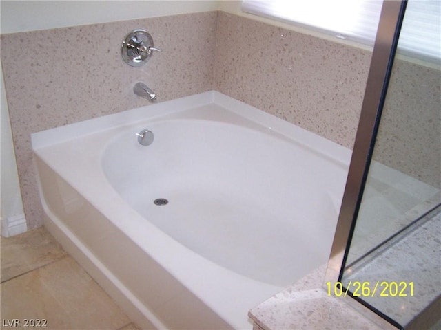 bathroom featuring a washtub and tile flooring