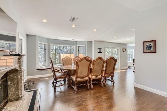 dining space with dark wood-type flooring and a high end fireplace