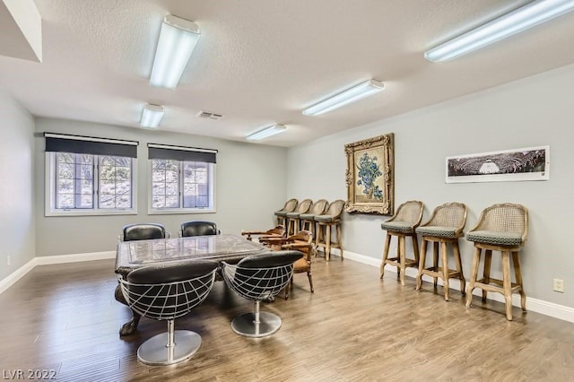 dining area featuring a textured ceiling and hardwood / wood-style floors