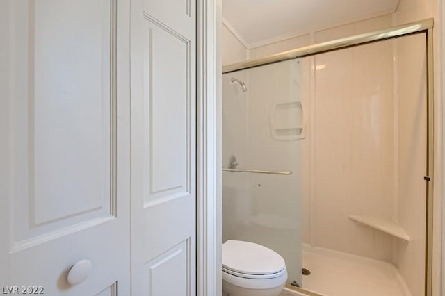 bathroom with a shower with door and toilet