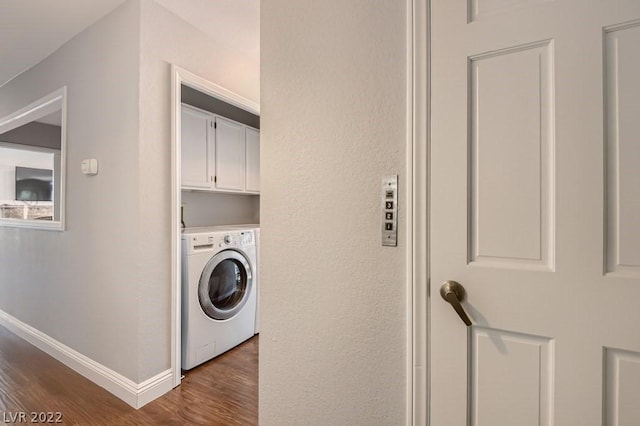 washroom featuring cabinets, dark hardwood / wood-style flooring, and washer / dryer