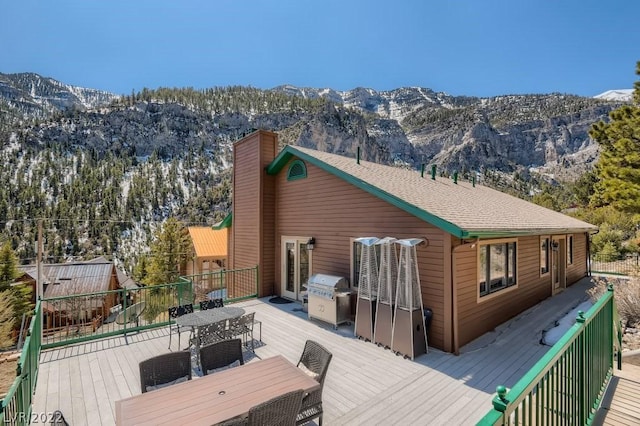 back of property with a deck with mountain view