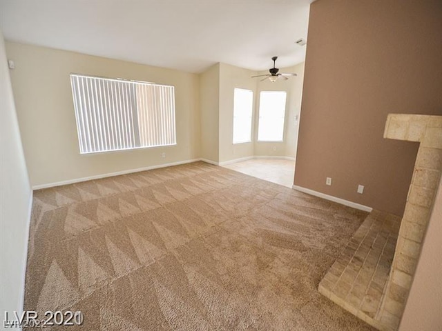 empty room featuring ceiling fan and light carpet