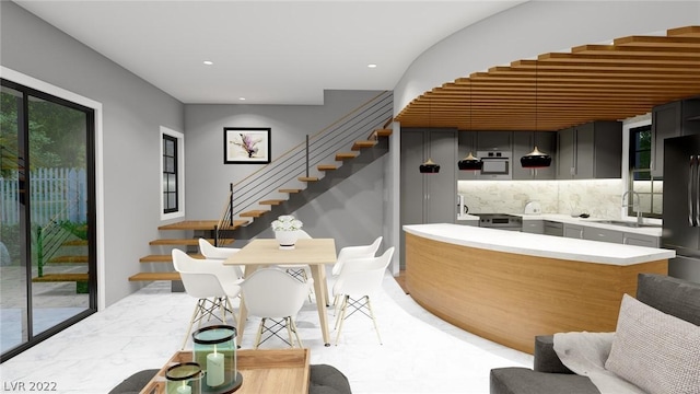 kitchen featuring tasteful backsplash, black refrigerator, gray cabinetry, light tile floors, and sink