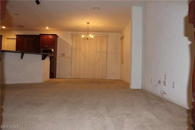 unfurnished living room with a notable chandelier and light colored carpet