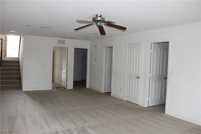 unfurnished bedroom featuring light carpet and ceiling fan