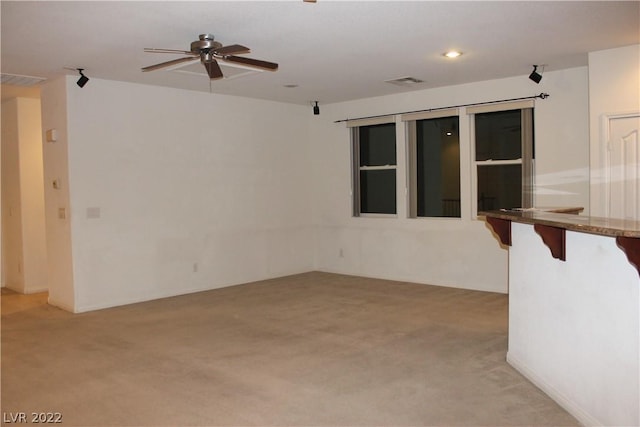 spare room with ceiling fan and light colored carpet