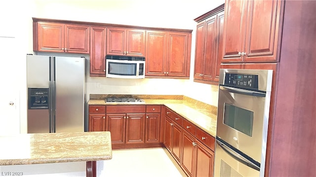 kitchen featuring stainless steel appliances and light stone counters