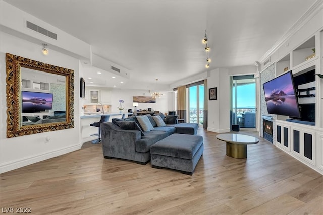 living room with a chandelier and light hardwood / wood-style flooring