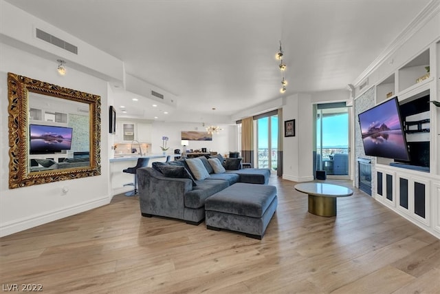 living room featuring light hardwood / wood-style floors and a notable chandelier