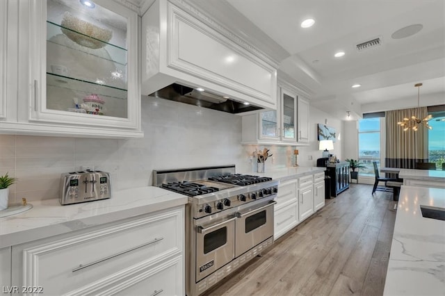 kitchen with a chandelier, tasteful backsplash, white cabinetry, double oven range, and light hardwood / wood-style flooring