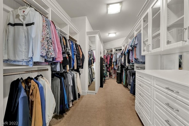 walk in closet featuring light colored carpet