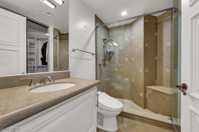 bathroom featuring toilet, tile floors, a shower with door, and vanity