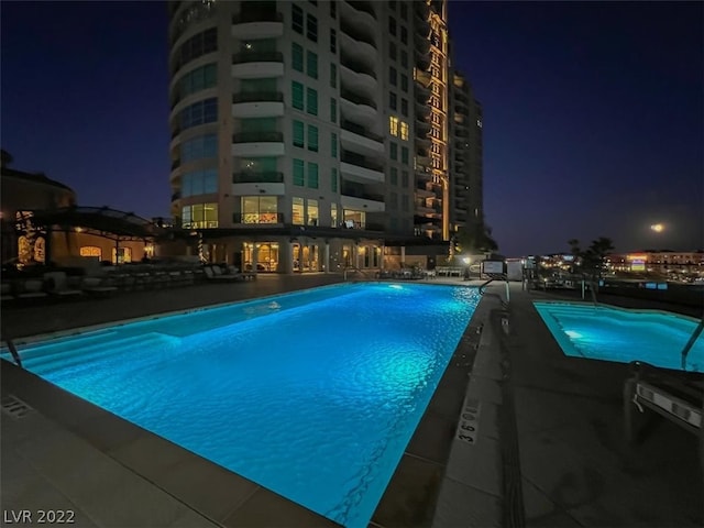 view of pool at twilight