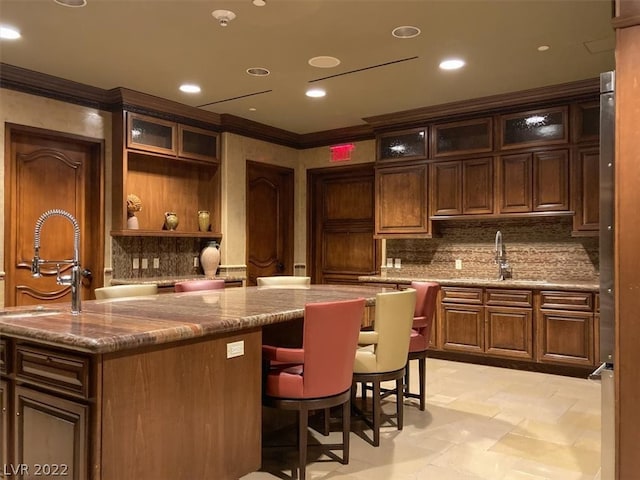 interior space with stone counters, sink, and tasteful backsplash