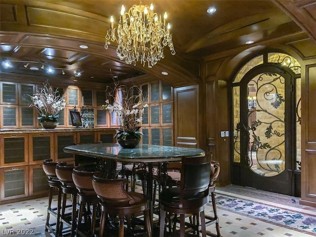 interior space featuring a notable chandelier, tile flooring, dark stone counters, and coffered ceiling