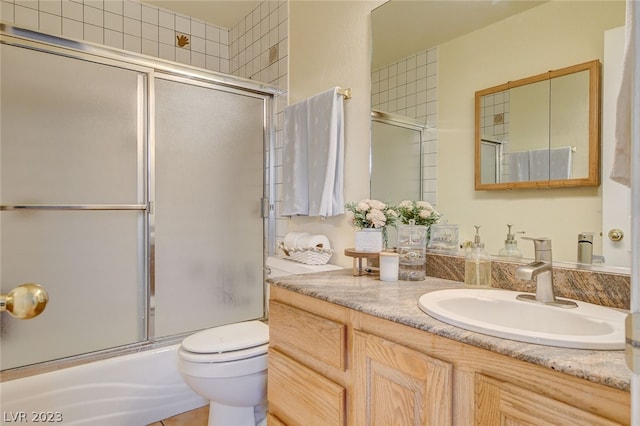 full bathroom with combined bath / shower with glass door, vanity, and toilet