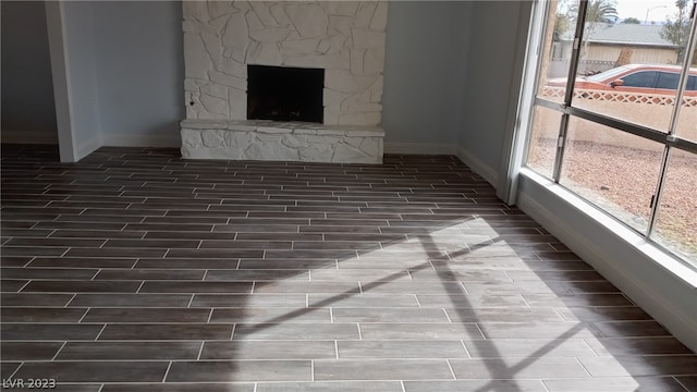 unfurnished living room with plenty of natural light and a fireplace