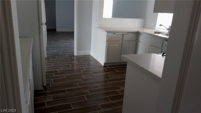 kitchen featuring white cabinets, dark wood-type flooring, sink, and white refrigerator