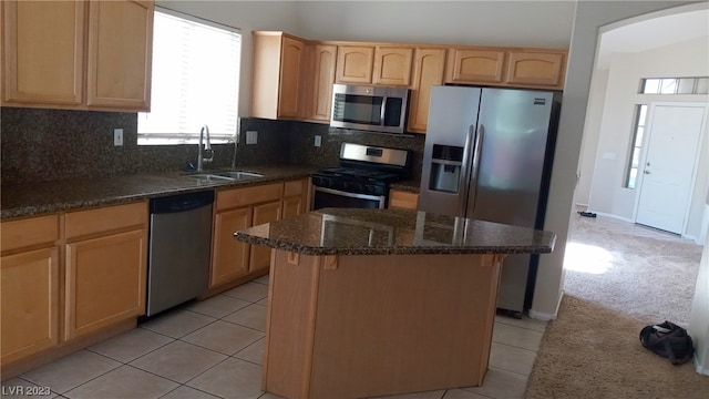 kitchen with appliances with stainless steel finishes, tasteful backsplash, a center island, sink, and light carpet