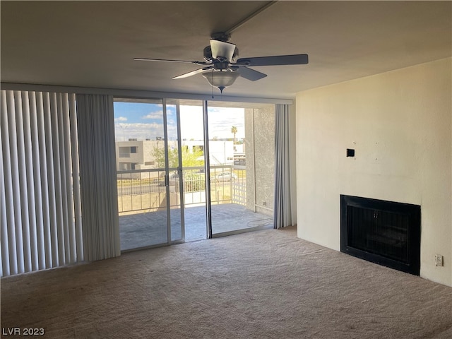 carpeted empty room featuring expansive windows and ceiling fan