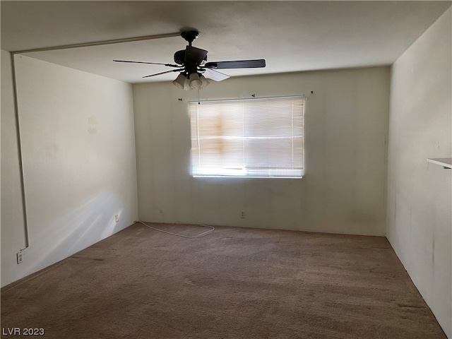 carpeted spare room featuring ceiling fan