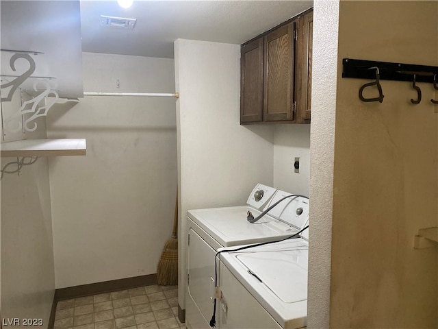 laundry area featuring washing machine and clothes dryer, cabinets, electric dryer hookup, and light tile floors