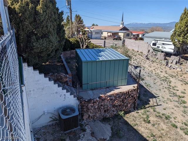 view of yard with central air condition unit and a storage shed