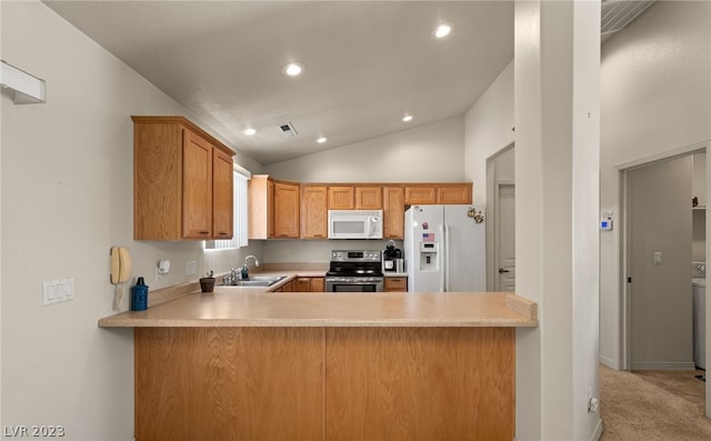 kitchen featuring light carpet, white appliances, kitchen peninsula, vaulted ceiling, and sink