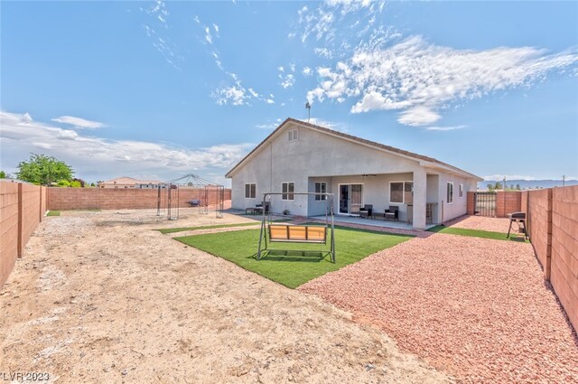 back of property featuring a lawn and a patio