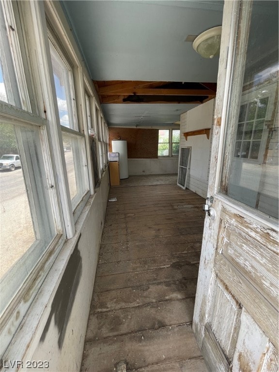 hall featuring beamed ceiling, dark wood-type flooring, and gas water heater